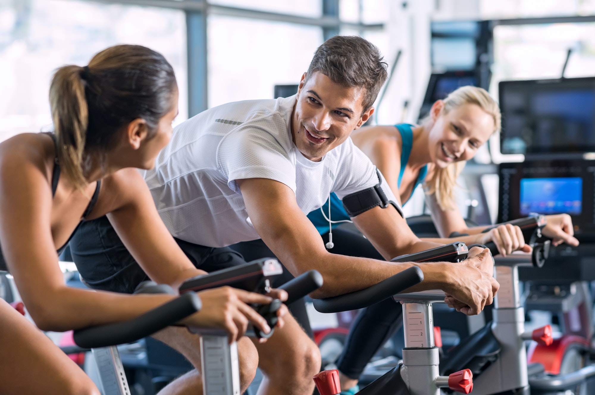 Fit people cycling at gym